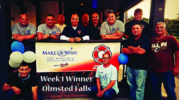 Group of men posing behind a Make-A-Wish Ohio, Kentucky & Indiana banner with balloons and Week 1 Winner Olmsted Falls sign.
