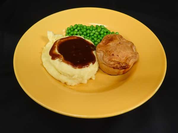a side of mashed potato and gravy, peas, and a biscuit on a yellow plate