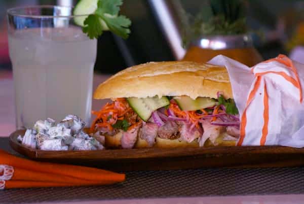 Bold pork bánh mì with tender grilled pork, pickled veggies, fresh herbs, and cucumbers on a toasted baguette — a vibrant fusion sandwich with savory, tangy, and crunchy perfection.