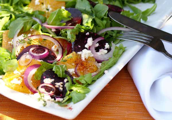 A fresh mix of organic greens, roasted beets, orange segments, red onions, and crumbled cheese — a vibrant seasonal salad bursting with color, flavor, and farm-to-table goodness.