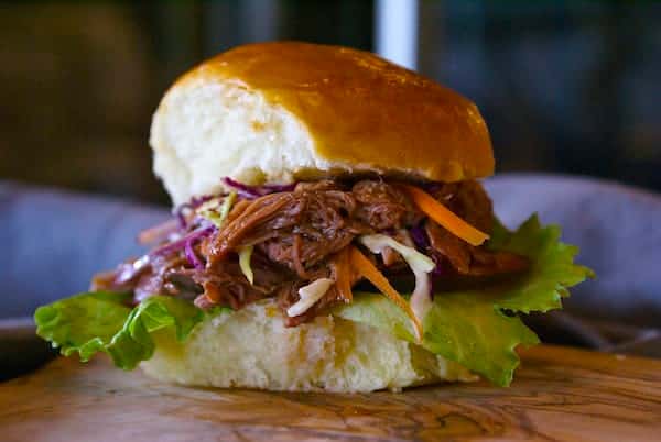 Tender pulled pork piled high with tangy slaw and crisp lettuce on a soft brioche bun — a sweet, smoky Southern-style slider packed with bold BBQ flavor.