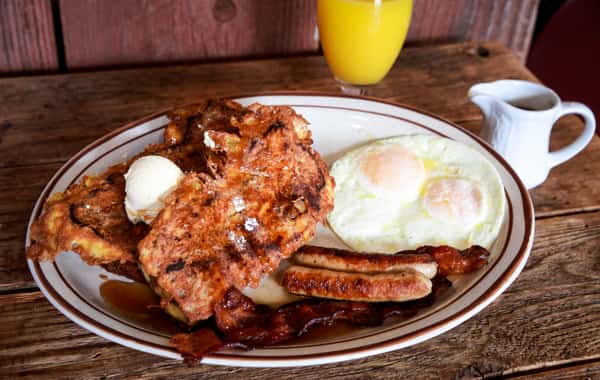 A comforting country breakfast featuring crispy fried chicken, eggs cooked to order, toast, and classic breakfast sides. The warm presentation captures the homestyle cooking Judy's Country Kitchen is known for.