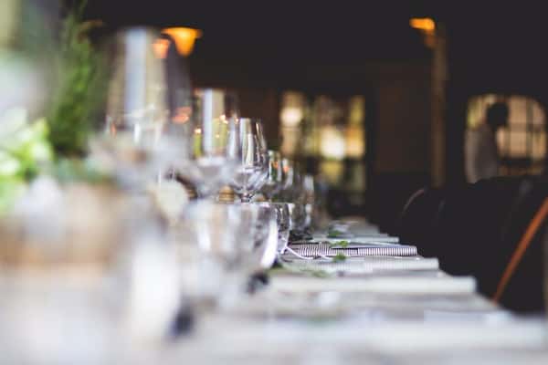 Elegant restaurant table setting with crystal wine glasses, white napkins, and ambient lighting, perfect for fine dining or a private event.