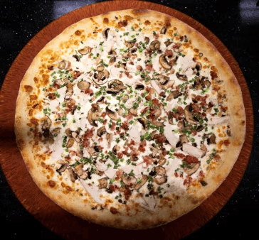 white pizza topped with mushrooms, bacon, herbs, and creamy cheese sauce