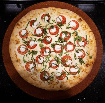 margherita pizza with fresh tomato slices, mozzarella, basil, and balsamic drizzle on a golden crust