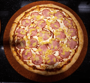 hawaiian pizza with ham, pineapple chunks, and melted mozzarella on a classic crust