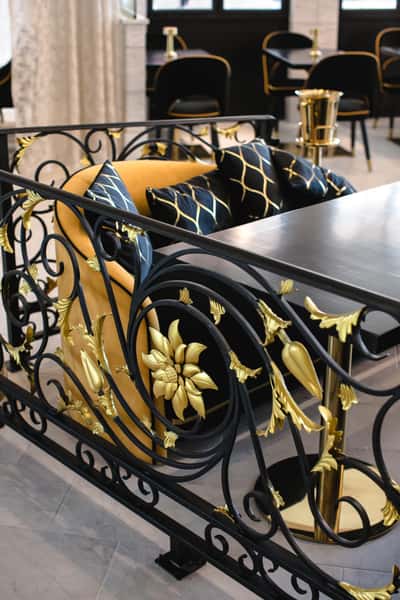 Elegant dining area with plush gold seating and intricate metal work.