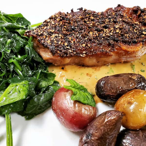 crusted salmon with a side of spinach and potatoes