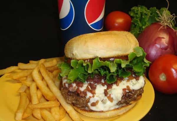 cheeseburger with lettuce, tomato, bacon bits and a side of french fries