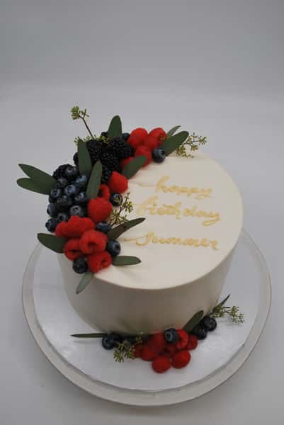 single cake with fresh berry top and on board