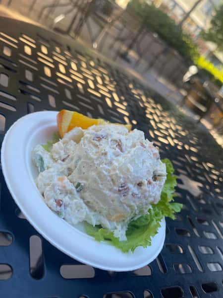 A fresh and creamy chicken salad is served on a bed of crisp green lettuce on a white plate. The dish looks light and refreshing, with finely chopped ingredients mixed into the creamy salad, perfect for a satisfying lunch.