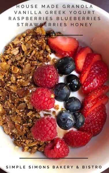 A colorful breakfast bowl filled with crunchy granola is topped with fresh strawberries, raspberries, and blueberries. The vibrant mix of berries adds natural sweetness and color, creating a healthy and refreshing dish perfect for a nutritious start to the day.