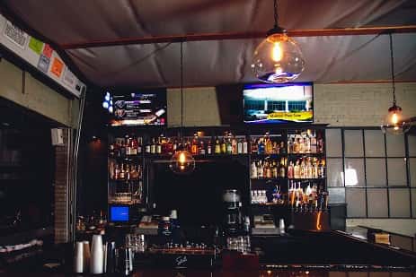 close-up view of behind the bar with two televisions