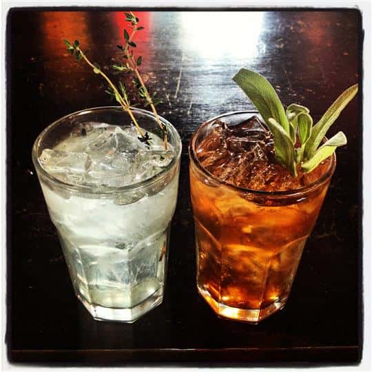 glass of water with ice, and glass of tea with ice on a table