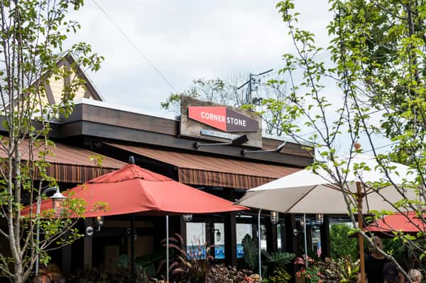 Corner Stone restaurant exterior with patio umbrellas and greenery in a casual outdoor setting