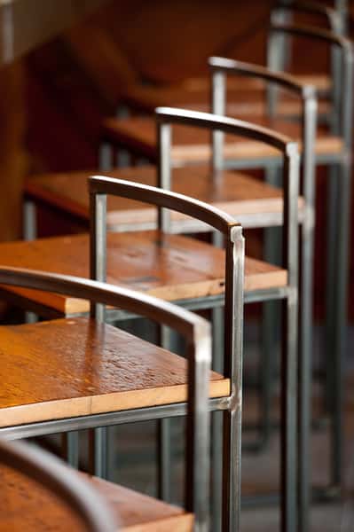 Industrial-style bar stools with wood seats and metal frames in a restaurant setting