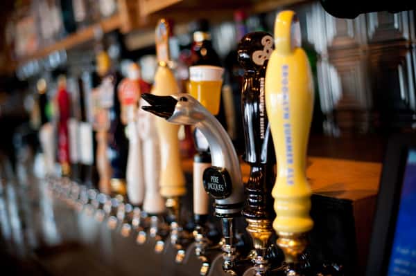 Close-up of craft beer taps with decorative handles on a polished bar counter
