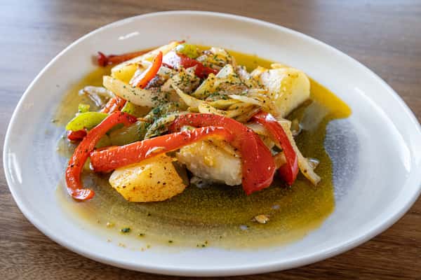 A fish fillet (possibly cod or bacalhau) cooked with bell peppers, onions, and olive oil.