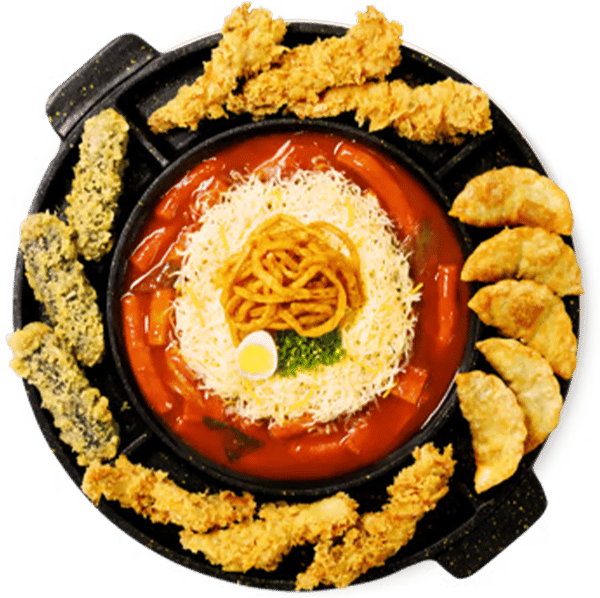 Korean tteokbokki served in a hot pan with fried dumplings, crispy tempura, and golden fried chicken strips.