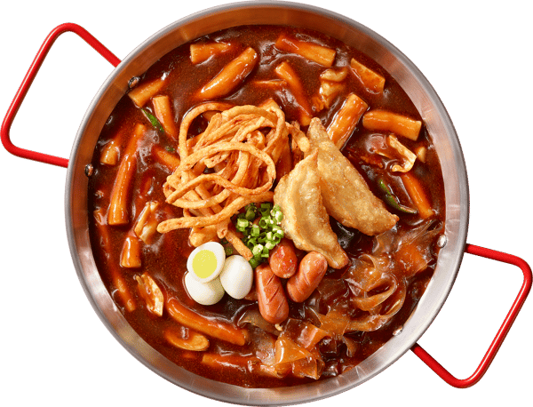 A bowl of spicy Korean tteokbokki with fish cakes, quail eggs, dumplings, sausages, and crispy fried noodles in red chili sauce.