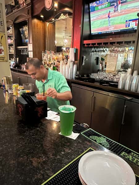 Bartender serving St. Patrick Day drinks at YFC Cedar.
