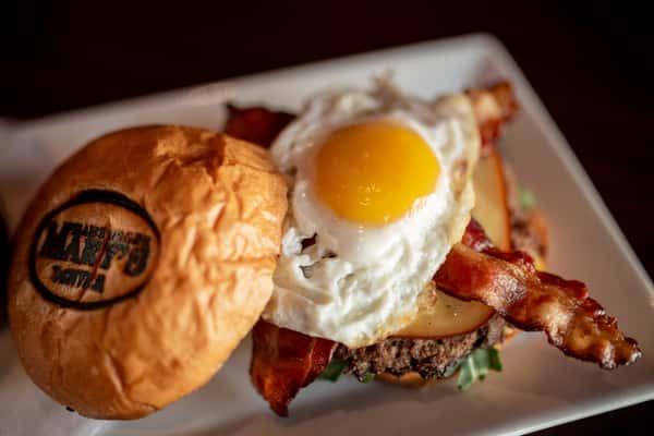 Table with burger with egg and bacon.
