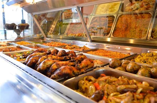 various buffet trays filled with assorted foods