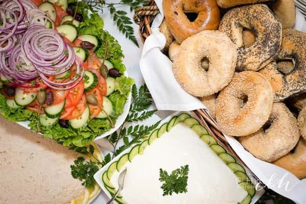 catering display with salad, bagels, cream cheese and other various toppings