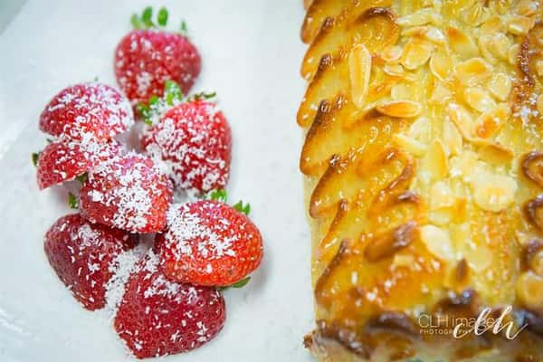 strawberries topped with powdered sugar and a pastry with apples on top