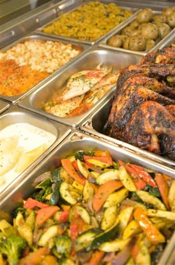 various buffet trays filled with assorted foods