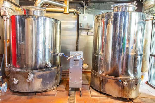 Stainless steel brewing tanks inside a working brewery production area