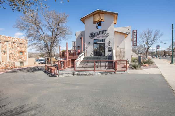 Front view of brewery building with outdoor seating and street view in a neighborhood setting