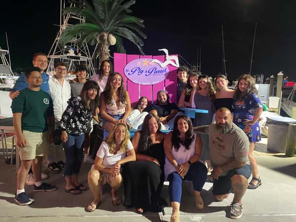guests on dock in front of boat