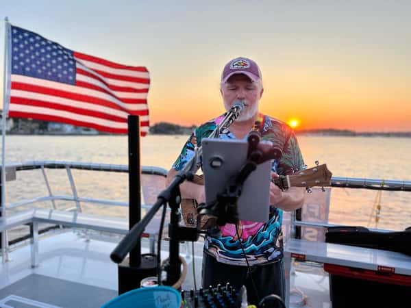 Singer on boat with flag in background