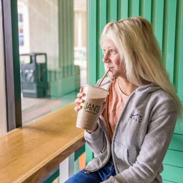 A customer enjoying a Peanut Butter Banana Date Smoothie from Jan's Health Bar.