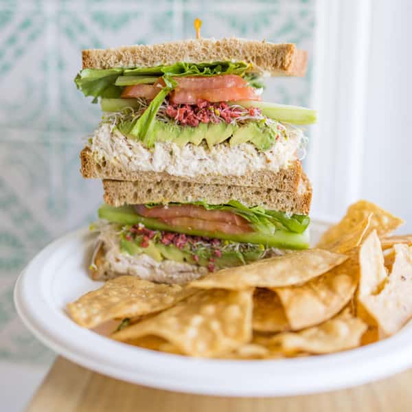 Poppy Holguin, owner of Jan's Health Bar, celebrating owning Jan's Health Bar for 15 years with a Jan's Classic Sandwich and Strawberry Delight smoothie.