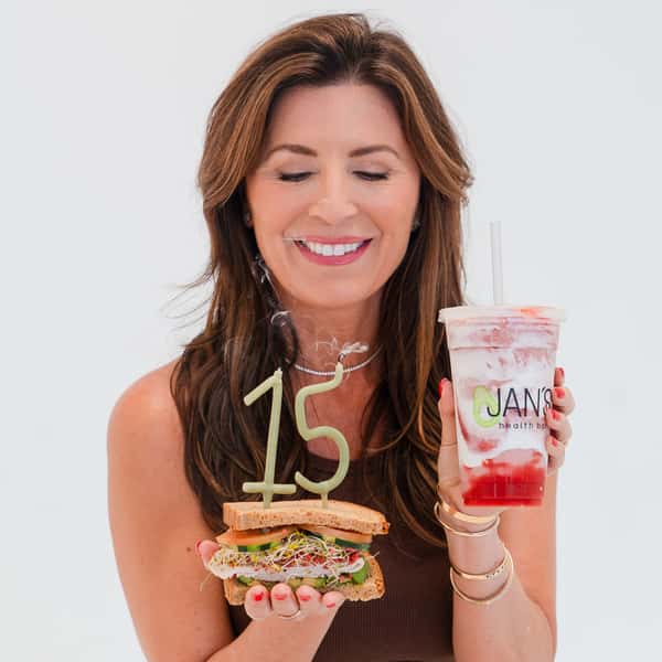 Poppy Holguin, owner of Jan's Health Bar, celebrating owning Jan's Health Bar for 15 years with a Jan's Classic Sandwich and Strawberry Delight smoothie.