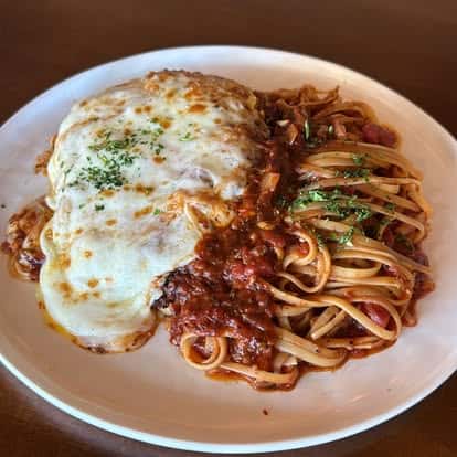 A breaded cutlet topped with marinara and melted cheese, served with spaghetti in tomato sauce.