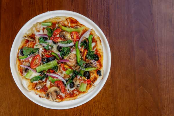 Veggie pizza topped with spinach, tomato, bell pepper, onion, olives and mushrooms