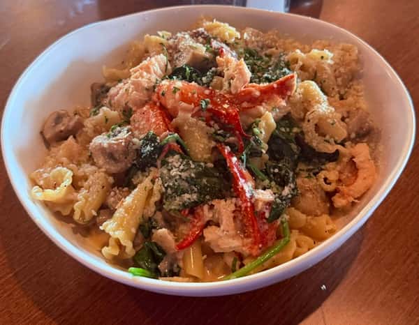 Pasta tossed with shrimp, spinach, and red peppers in a savory sauce