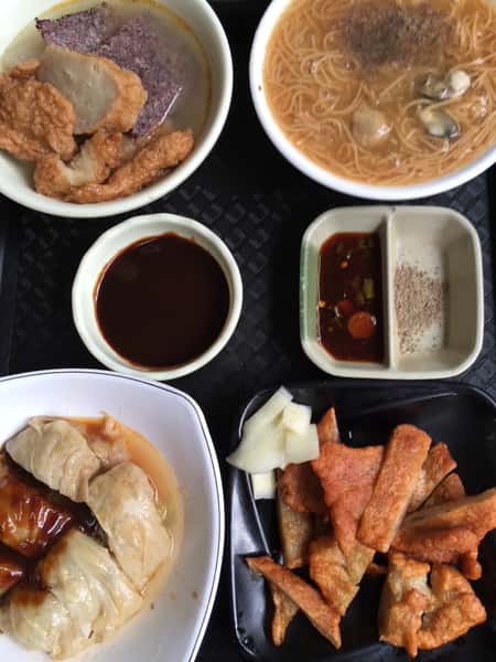 Taiwanese meal with oyster noodles, dumplings, fried appetizers, sauces, and side dishes