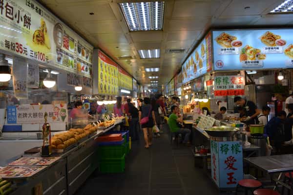 Vendors serving Taiwanese street food inside the bustling underground food court at the Shilin Market in Taipei, Taiwan.