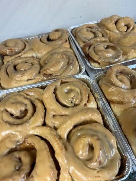 Freshly glazed cinnamon rolls in aluminum trays