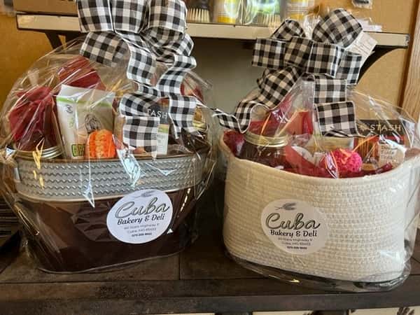 Two gourmet gift baskets from Cuba Bakery & Deli wrapped in cellophane with checkered bows