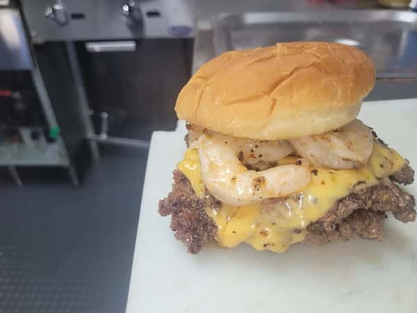Cheeseburger topped with melted cheese and grilled pineapple, photographed in the kitchen
