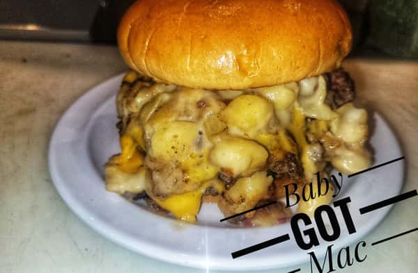 Burger topped with cheese sauce and jalapeños
