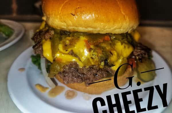 Burger topped with melted cheese, green chile, and lettuce