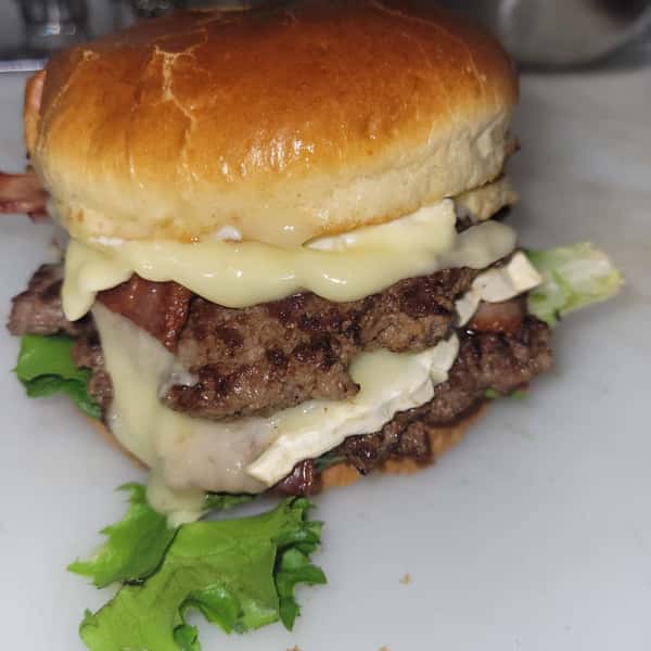 Burger topped with melted cheese, caramelized onions, and lettuce
