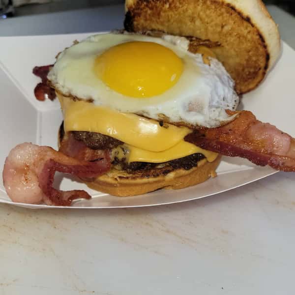 Bacon cheeseburger topped with a fried egg on a toasted bun