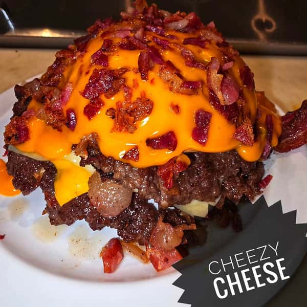 Loaded cheeseburger smothered in cheese sauce and bacon bits